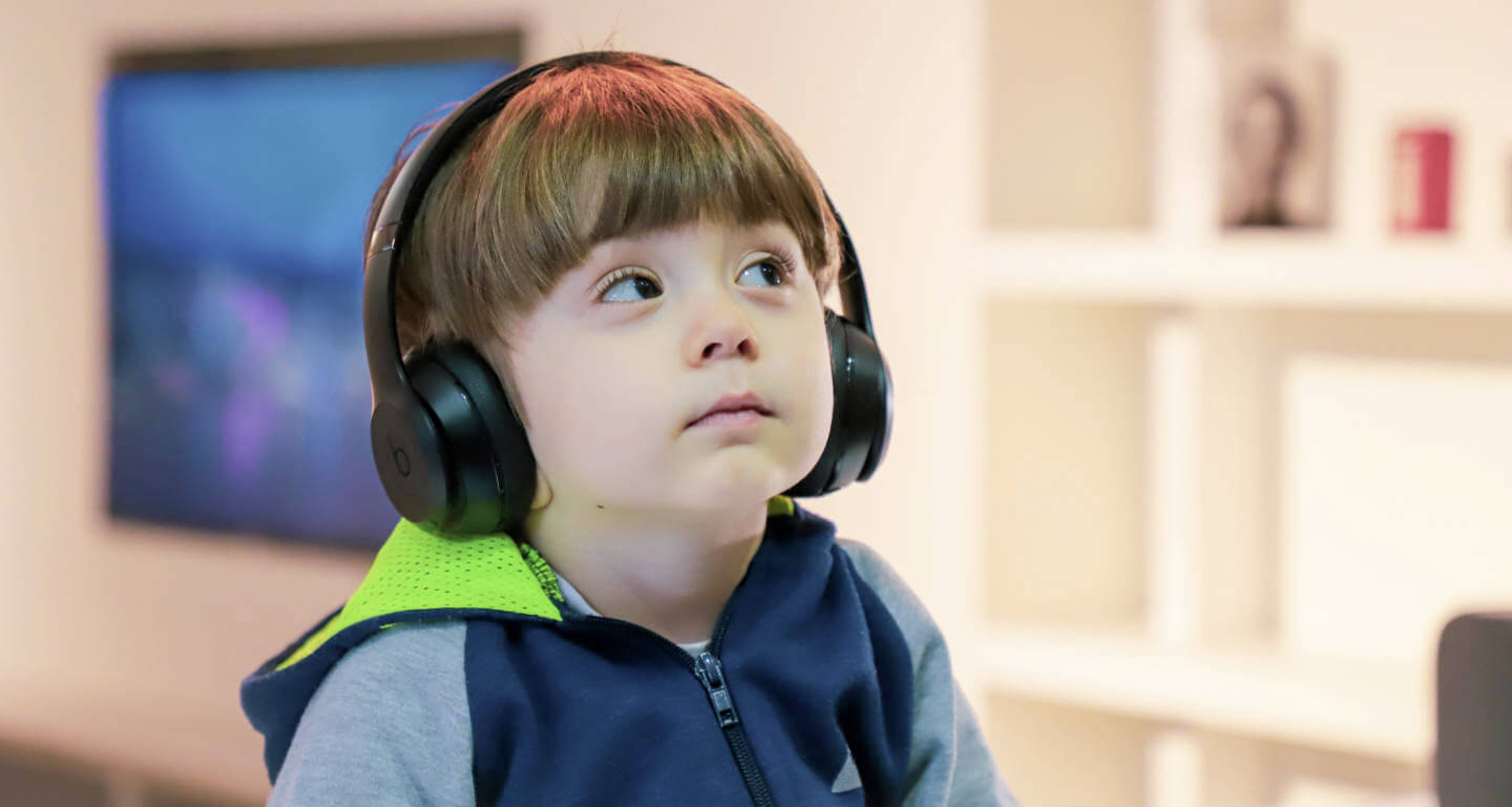 Kind hört auf Kopfhörern einen Podcast